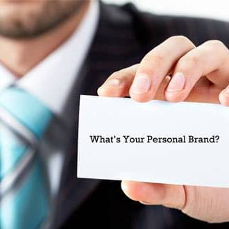 persona con biglietto da visita recante scritta: what's your personal brand?