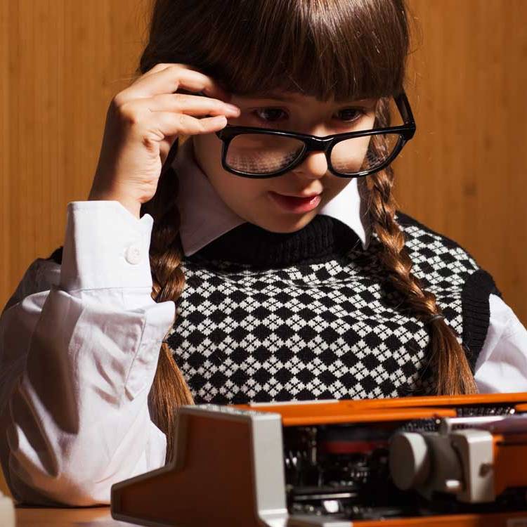 nell'immagine una bambina intenta a scrivere a macchina: concept per il blog di Creativi Digitali