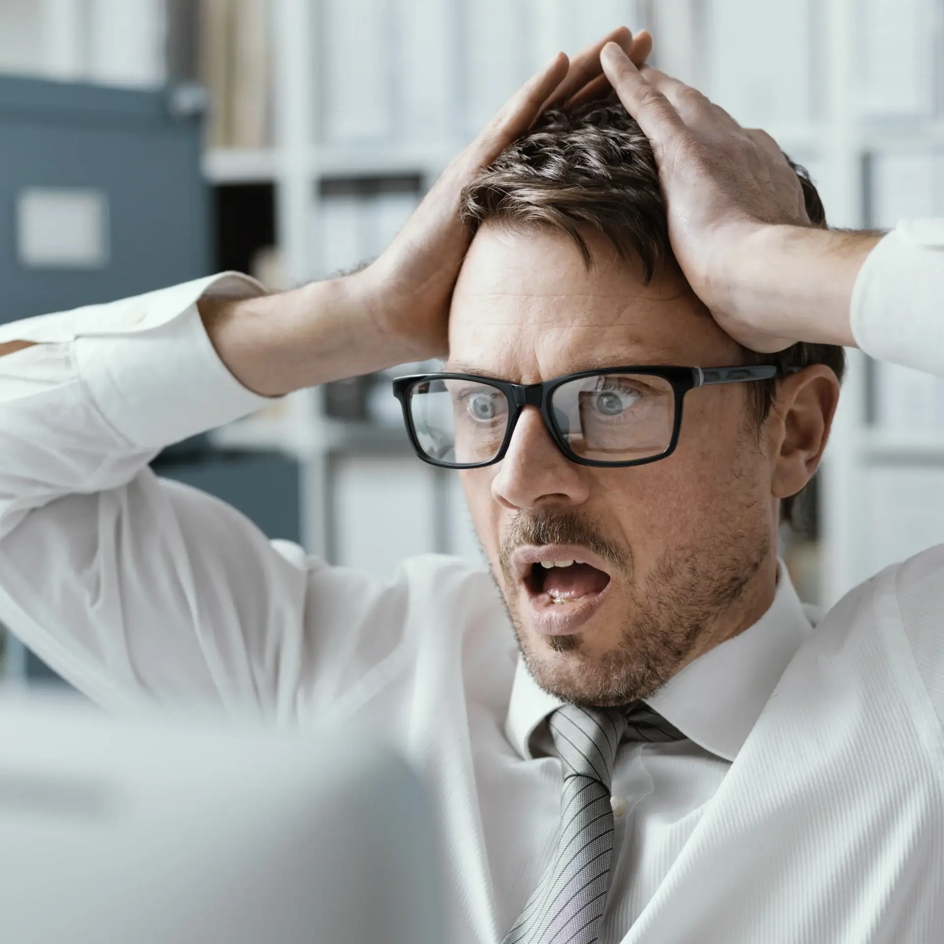 Concept per Content Marketing VS AI Overview: uomo con sguardo di panico davanti allo schermo del computer